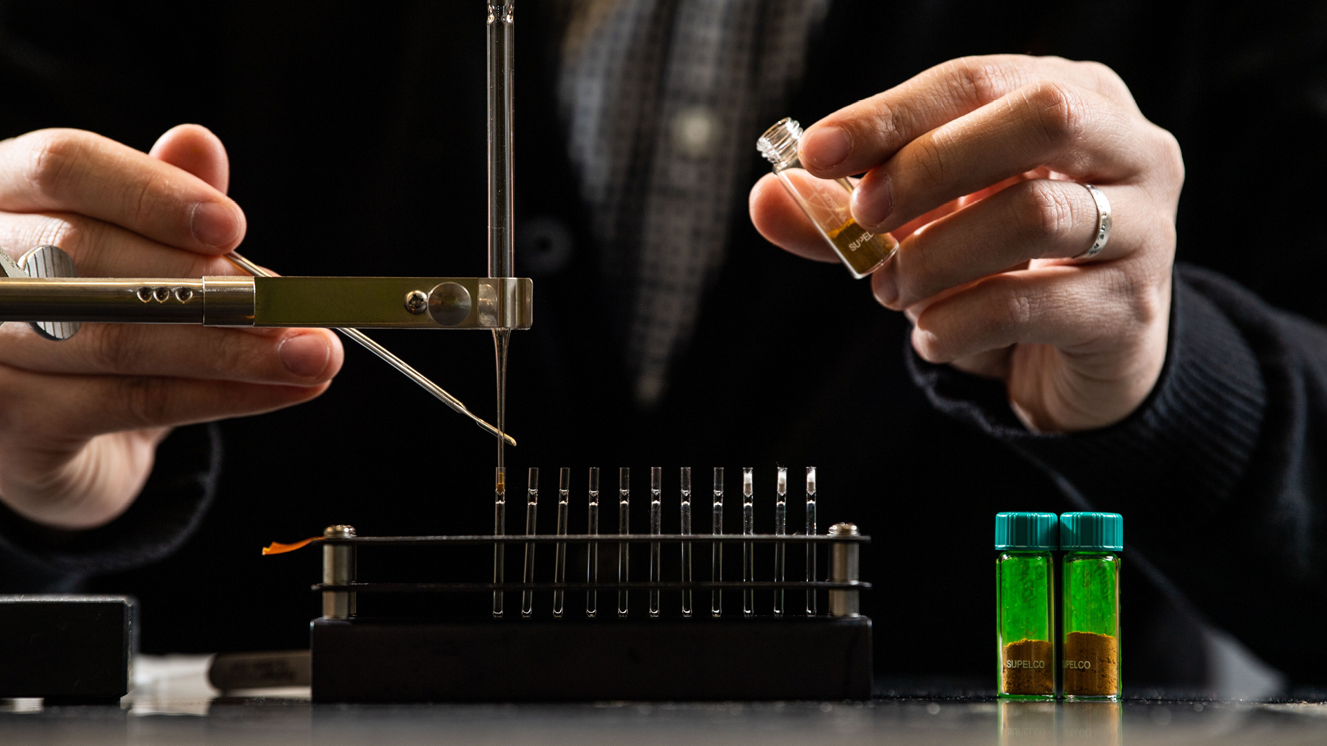 Photo of a researcher's hands holding pyrolysis gas chromatography-mass spectrometry equipment.