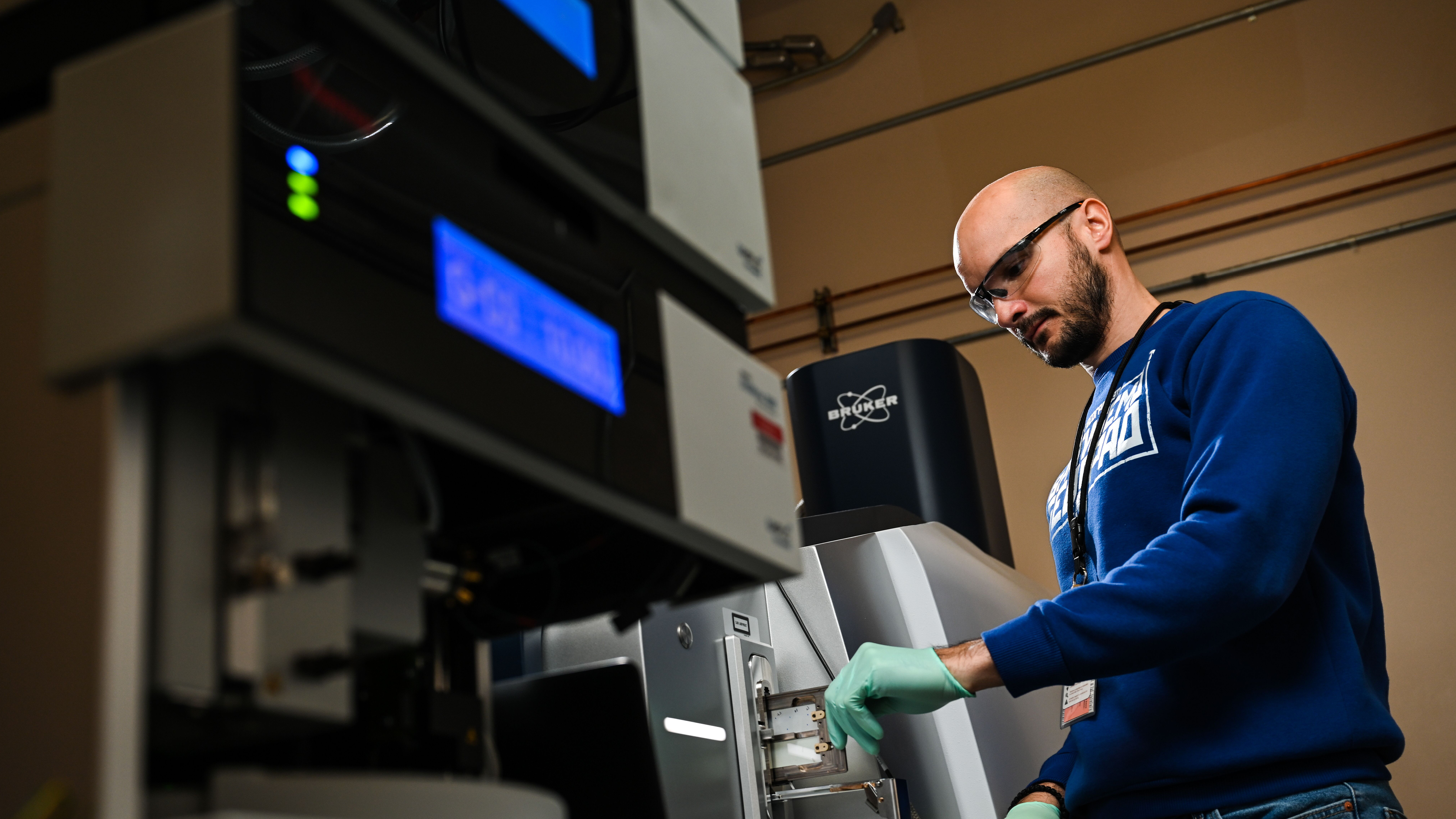 Photo of researcher Dušan Veličković loading a sample into a MALDI-ScimaX mass spectrometer instrument.
