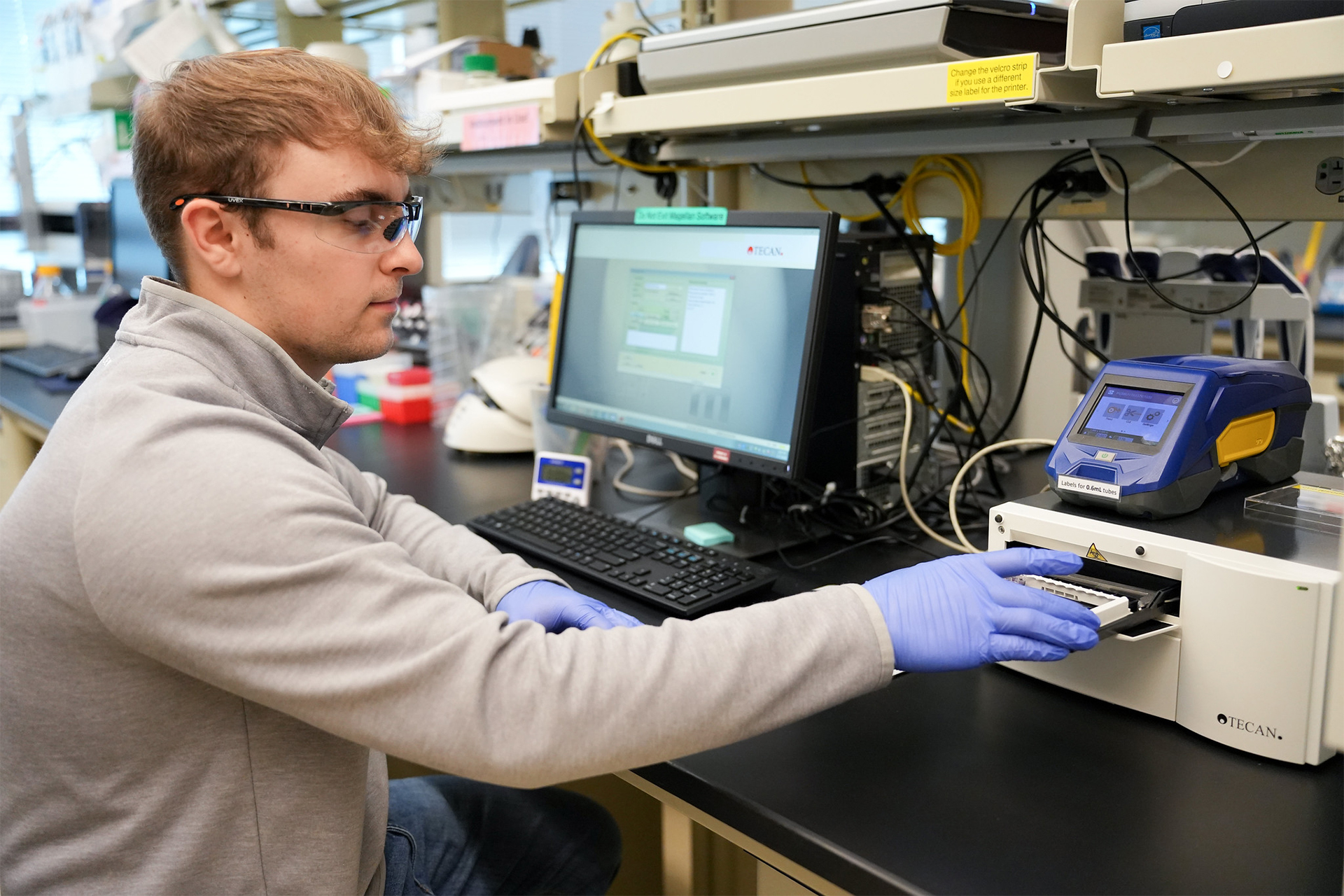 Photo of researcher Chase Robertson seated at a laboratory station, working with equipment.