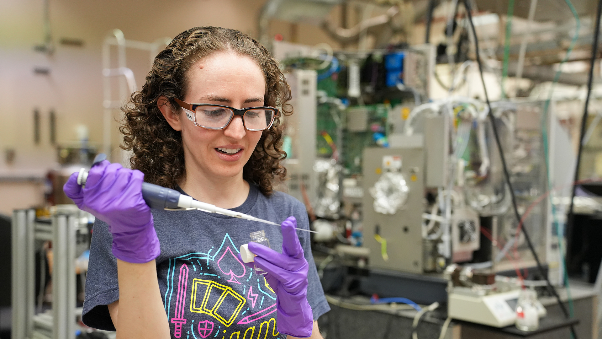 Photo of researcher Ashley Ives examining a lengthy pipette.