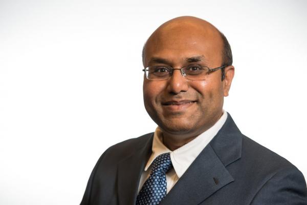 man with glasses wears collared shirt and tie