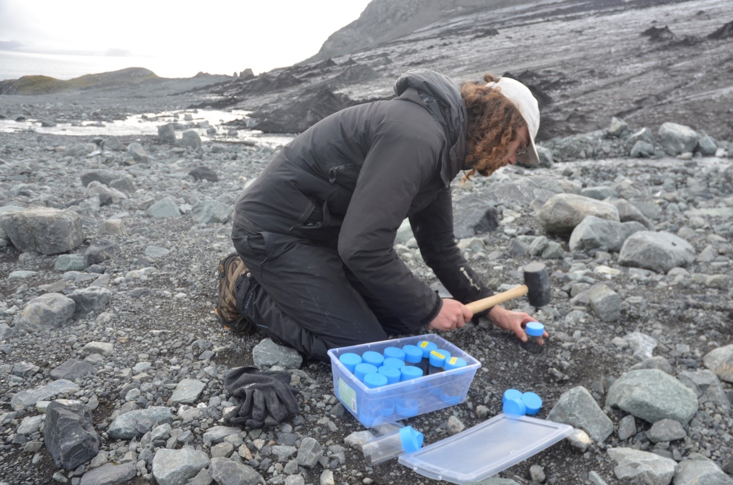 Scott Sugden uses hammer-shaped tool to conduct field work.