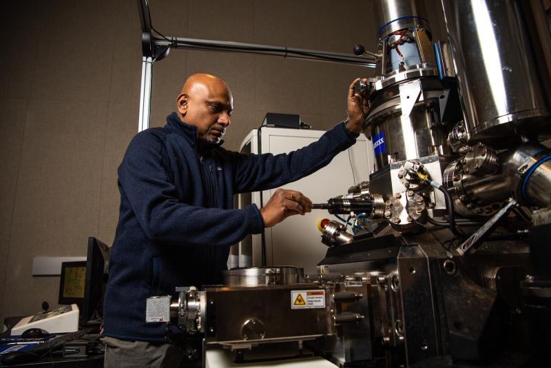 Shuttha Shutthanandan prepares to load a sample into the HIM.