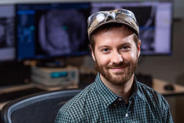 Trevor Moser sits in front of the Aquilos instrument.