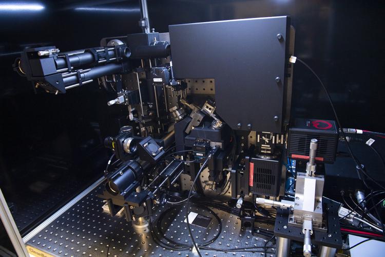 photo of a black instrument sitting on a metal platform with holes.