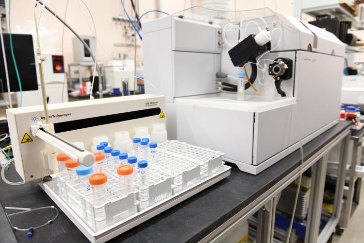 Photograph of the white Inductively Coupled Plasma Mass Spectrometry instrument with orange and blue sample tubes