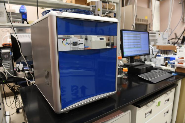 photo of a blue ion chromatography instrument sitting on a desk in a laboratory