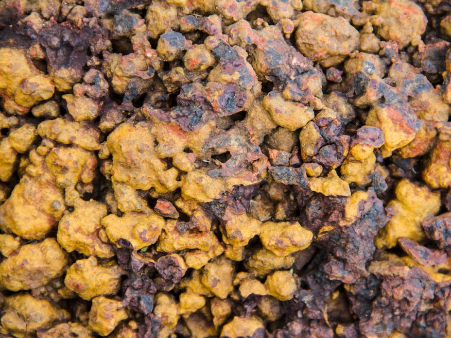 Photo of a pile of laterite stone, which displays in yellow and brown tones