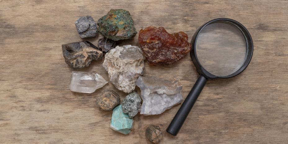 Rocks of different sizes and shapes next to a magnifying glass