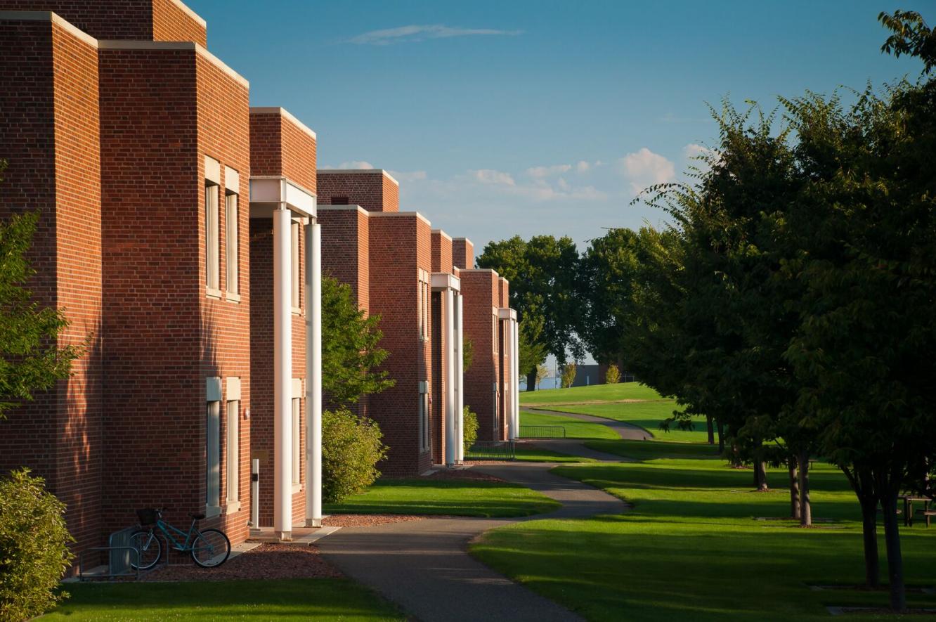 photograph of brick buildings, trees, and grass