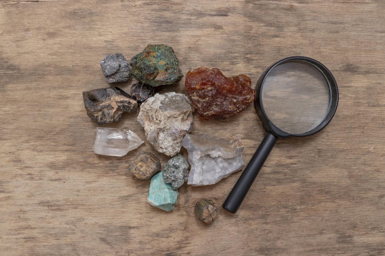 Rocks of different sizes and shapes next to a magnifying glass