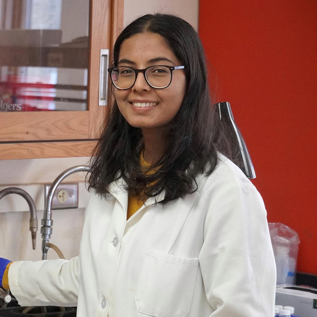 Photo of UW-Madison PhD student Soni Ghimire standing in a lab setting, smiling at the camera.