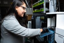 researcher loads samples into instrument