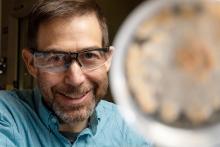 Photo of researcher Scott Baker in a laboratory setting, smiling at the camera.
